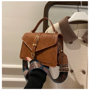 Dettaglio borsa vintage marrone con tracolla in tessuto colorato stile bohémien chic