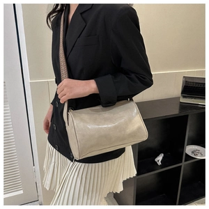 Beigefarbene Zylindertasche mit Jacquard-Gurt am Model für einen modernen Look