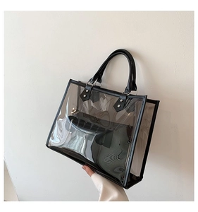 Close-up of transparent PVC tote bag with black leather trim and metal rivet details