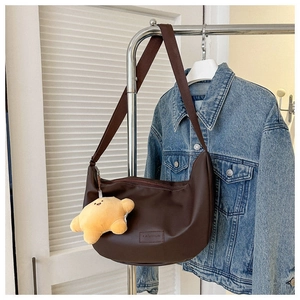 Brown leather hobo bag with yellow star plush charm and embossed fashion text detail