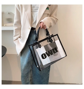 Detail of transparent PVC tote bag featuring black leather trim and OWU printed insert