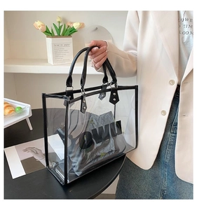 Detailed view of a transparent PVC tote bag with a black leather inner pouch and rivets