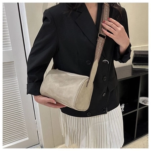 Beige Boston-Tasche in Zylinderform mit geometrischem Webgurt am Model gezeigt