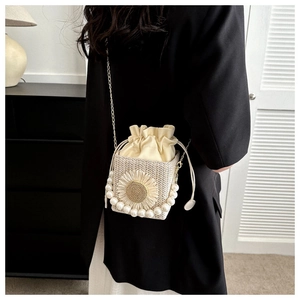 Detail of woven straw mini bag with pearl daisy flower and gold chain strap