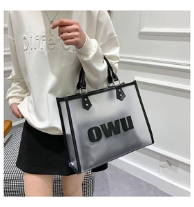 Detail showing translucent frosted tote bag with black leather trim and OWU lettering