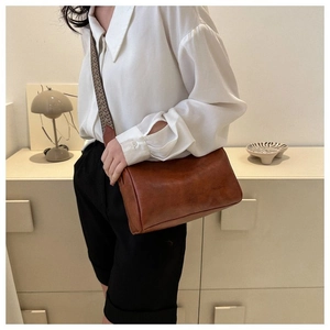Detail der karamellbraunen Retro-Zylindertasche mit geometrischem Vintage-Gurt