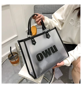 Detail view of translucent frosted tote bag featuring black OWU lettering and leather handles