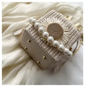Close-up of the reinforced leather bottom with protective metal studs on woven bucket bag
