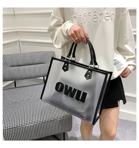 Detail of frosted PVC tote bag with black leather trim and metal rivet reinforcement