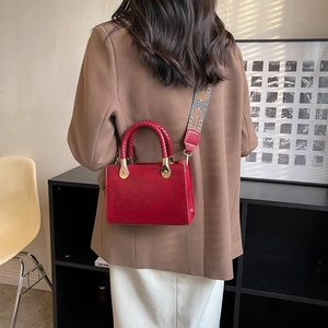 Borsa a tracolla in pelle rossa opaca con ampia tracolla etnica sulla schiena della modella