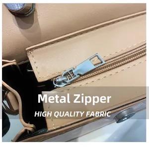 Close-up of premium silver metal hardware zipper on a light brown crossbody bag