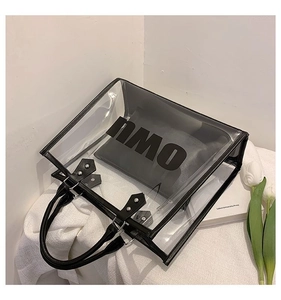 Detail view of transparent PVC tote bag with black leather trim and inner pouch