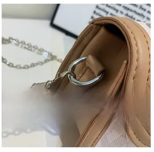 Detailed close-up of the electroplated gold hardware and chain strap on a saddle bag