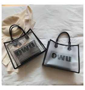 Detail of transparent and frosted PVC tote bags with OWU logo and leather handles
