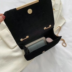 Black velvet quilted crossbody bag with gold chain strap and open interior view