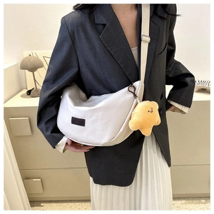 Detail view of cream dumpling crossbody bag with adjustable strap and star charm accessory