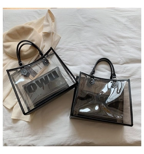 Close-up of transparent PVC tote bag with black leather trim and internal pouch