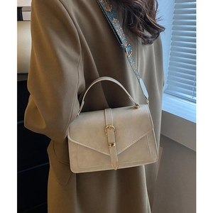 Elegante borsa beige con tracolla geometrica blu e manico superiore pratico
