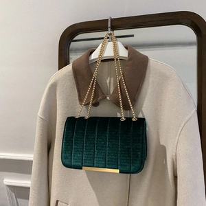 Dark green velvet shoulder bag with vertical quilting and elegant gold chain strap
