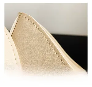 Detail showing the neat stitching and high-quality leather craftsmanship on the cream bag