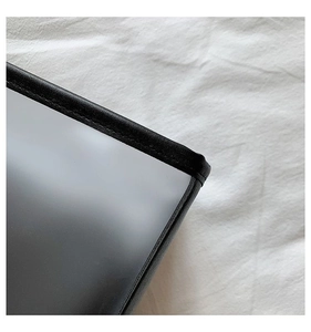 Macro shot of durable black leather edging and fine stitching on a translucent tote
