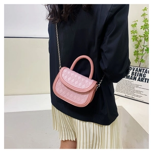 Side view of mini pink quilted saddle bag with gold chain strap on a model