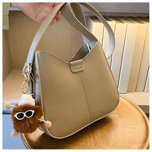 Detail of khaki leather bucket bag with FASHION metal buckle and cute bear charm