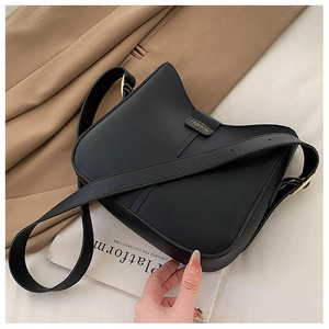Detail of black lychee grain leather bucket bag with gold buckle and fashion logo