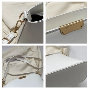 Detailansicht der weißen Beuteltasche mit goldenen Beschlägen, Nähten und verstellbarem Gurt