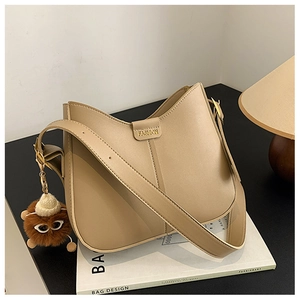 Detail view of beige hobo bucket bag with fashion embossing on a design book background