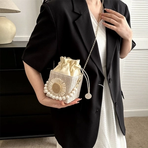 Chic cream woven bucket bag with sunflower detail, pearl handle and gold chain strap