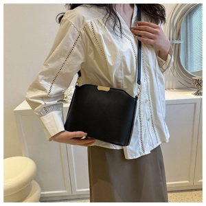 Detail einer schwarzen Vintage-Leder-Umhängetasche mit elegantem Goldmetall-Verschluss