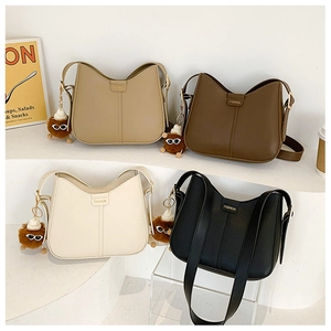 Minimalist hobo bags shown in four colors on a tiered stand with fashion accessories