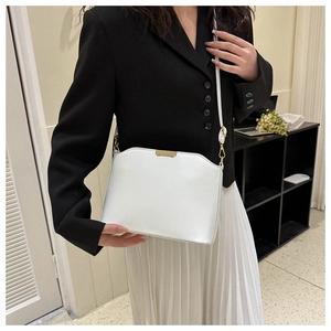 Minimalistische weiße Leder-Umhängetasche mit Metalldetails an einem Modell
