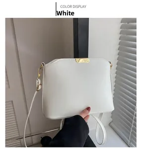 Detailansicht einer weißen Umhängetasche aus Leder mit eleganten Goldbeschlägen