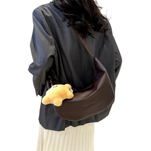 Dark brown crescent crossbody bag with fashion label and yellow star plush charm
