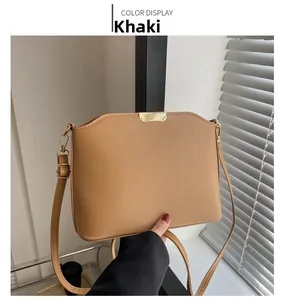 Detailansicht der khakifarbenen Beuteltasche mit Golddekor und Leder-Schultergurt