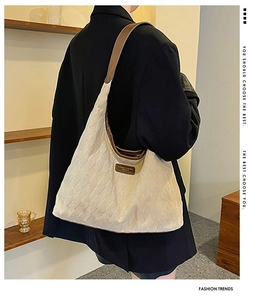 Détail du sac hobo en toile matelassée avec bandoulière en cuir et écusson de marque