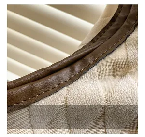Détails de couture en losange et bordure en cuir marron sur un grand sac en toile