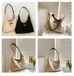 Détail de grands sacs fourre-tout en toile matelassée beige et noir avec anses en cuir