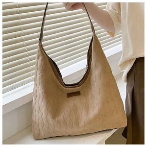 Détail du motif en losanges sur un sac cabas en toile kaki sous une lumière douce