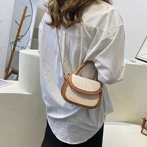 Minimalist beige saddle bag with brown trim and quilted texture shown on a model