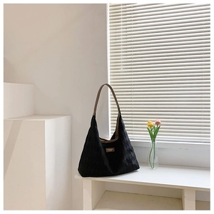 Détail du sac fourre-tout noir matelassé avec sangles brunes et décor de tulipes