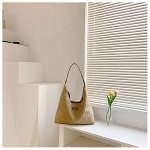 Détail du sac cabas matelassé kaki avec écusson en cuir et texture de losanges cousus