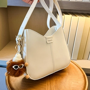 Cream bucket bag for women with wide shoulder strap and brown plush doll pendant charm