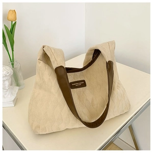 Gros plan du sac cabas matelassé avec étiquette et poignées en cuir marron de qualité