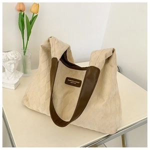 Détail du sac cabas matelassé beige avec anses en cuir marron et étiquette chic