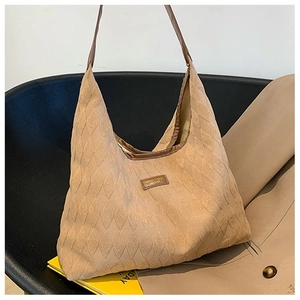 Détail du sac hobo en toile matelassée avec bandoulière en cuir et étiquette mode