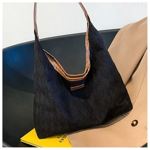 Détails du sac cabas matelassé en toile noire avec bandoulière en cuir marron