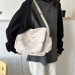Minimalist off-white messenger bag with DUO NING label shown on a model for daily style